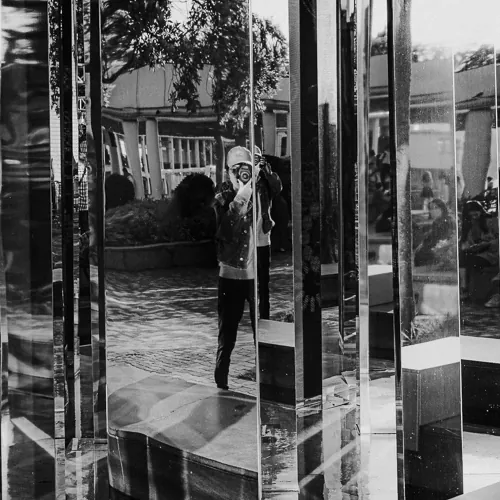 Self portrait in front of a mirror wall fountain installation.